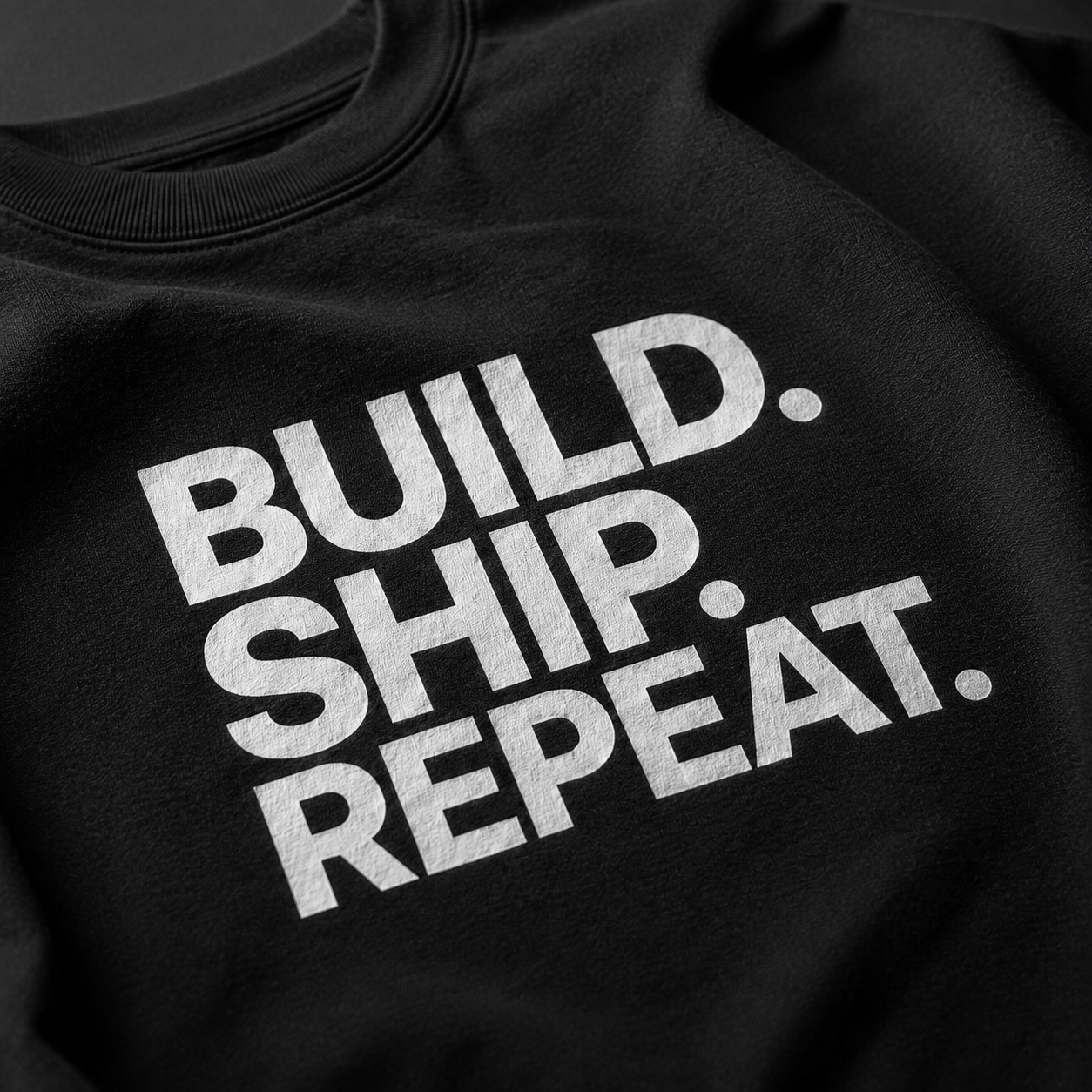 Black sweatshirt with 'BUILD. SHIP. REPEAT.' text in white on a plain background