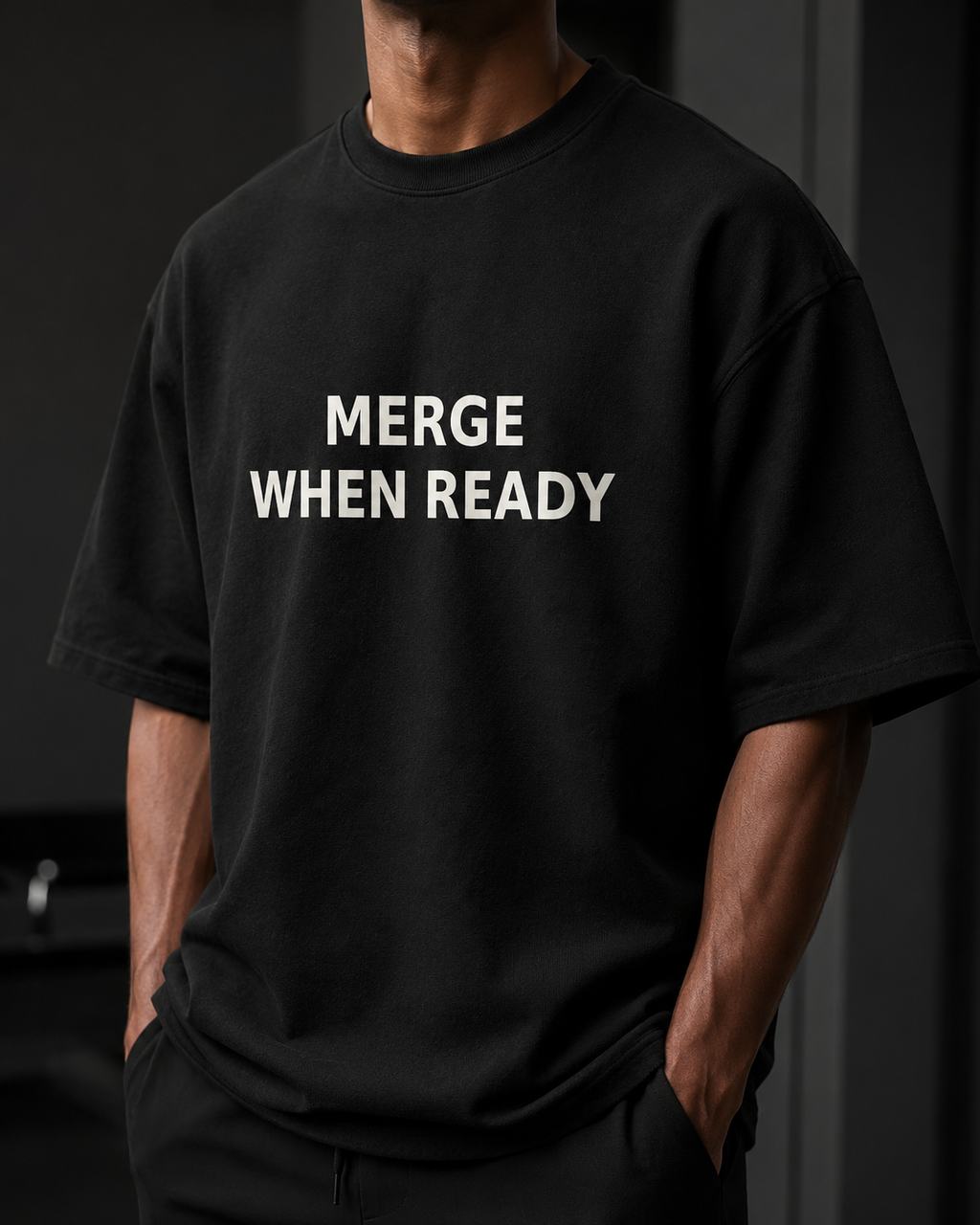 Person wearing a black t-shirt with 'MERGE WHEN READY' text on a dark background