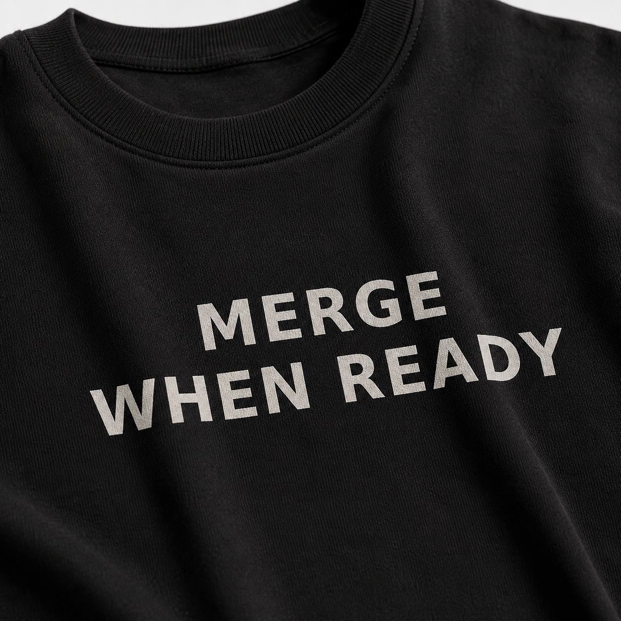 Black sweatshirt with 'MERGE WHEN READY' text on a plain background